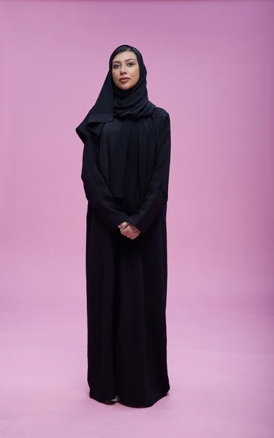 Saudi Woman in Abaya Standing on Pink Studio Background