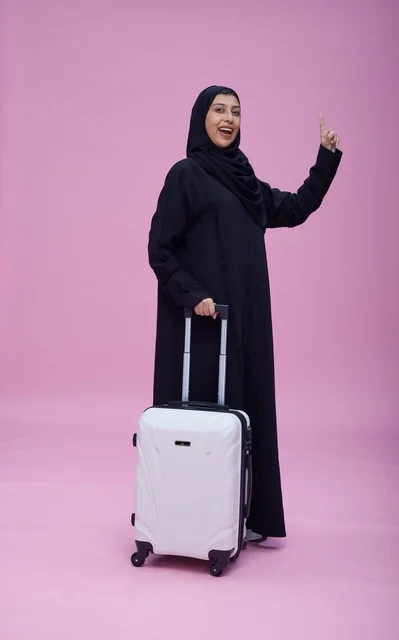 Saudi Woman with Travel Suitcase on Pink Background