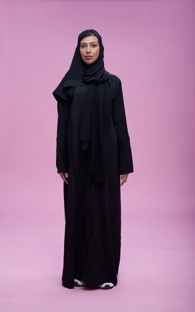 Saudi Woman in Traditional Black Abaya on Pink Background
