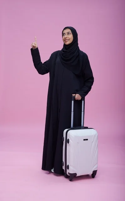 امرأة سعودية مع حقيبة سفر على خلفية وردية
