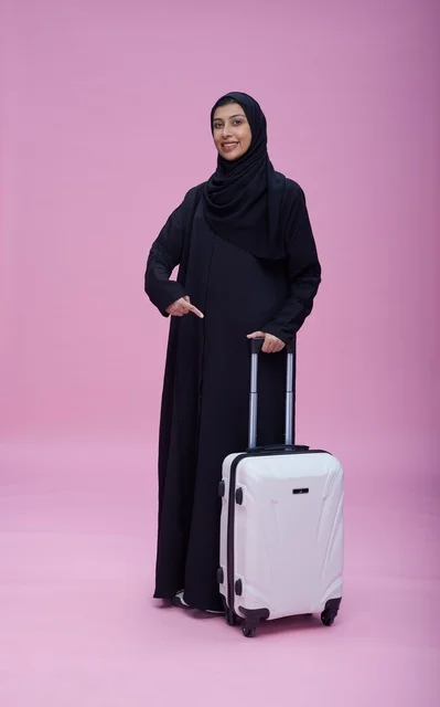 امرأة سعودية بالعباءة مع حقيبة سفر