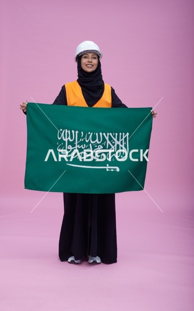 مهندسة سعودية تحمل علم المملكة العربية السعودية في استوديو