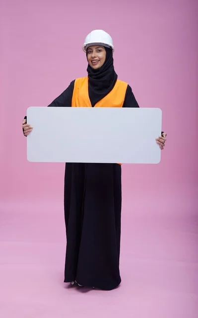 مهندسة سعودية ترتدي خوذة سلامة وتحمل لوحة بيضاء فارغة
