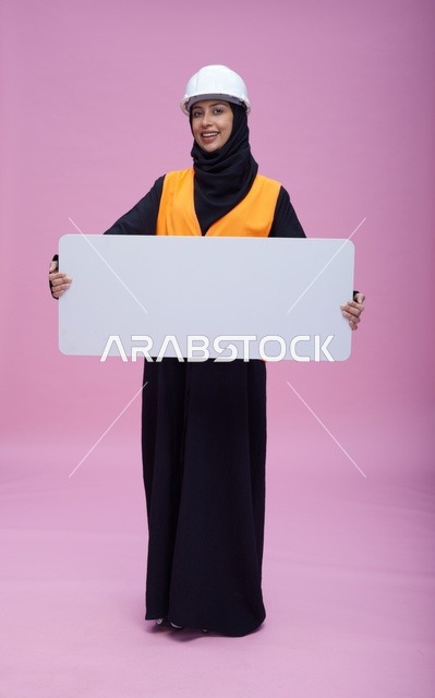 مهندسة سعودية تحمل لوحة عرض بيضاء فارغة