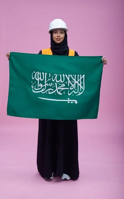 Saudi Female Engineer Holding Saudi Flag in Studio