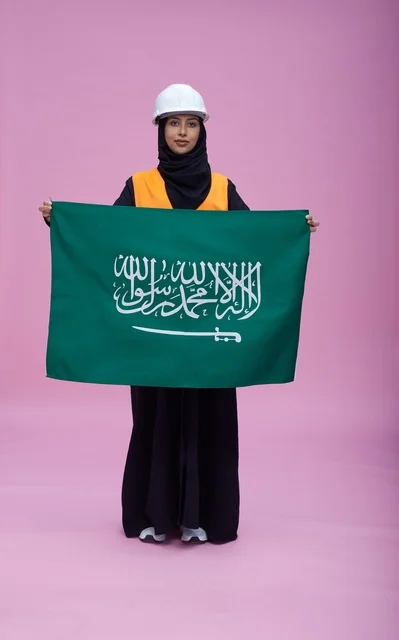 Saudi Female Engineer Holding Saudi Flag on Pink Background