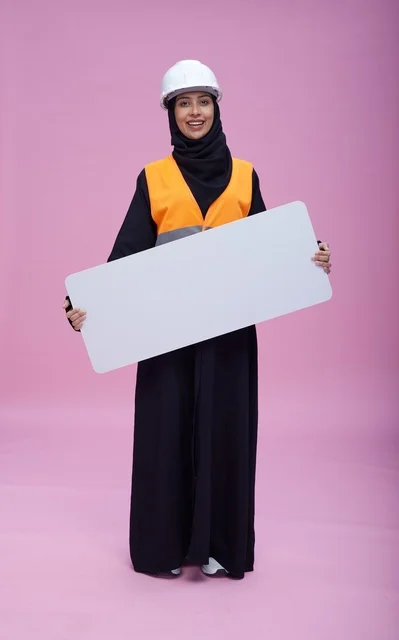 مهندسة سعودية تحمل لوحة عرض فارغة خلفية وردية