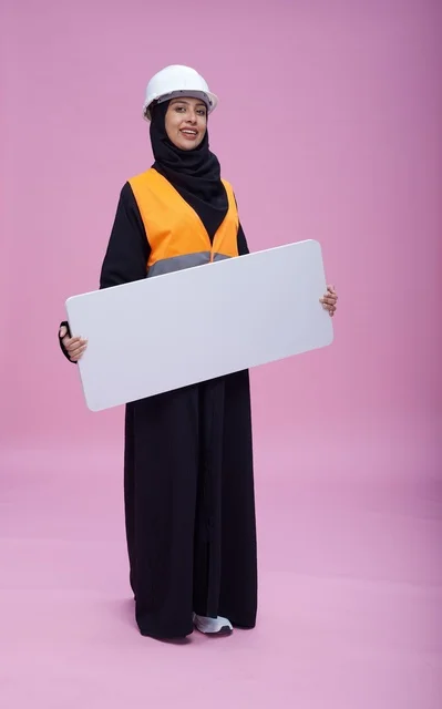 مهندسة سعودية تحمل لوحة عرض فارغة خلفية وردية