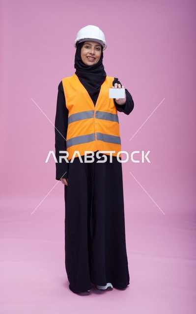 مهندسة سعودية تحمل بطاقة عمل بيضاء فارغة في الاستوديو