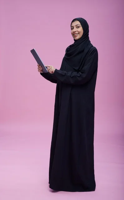 Saudi Woman with Tablet on Pink Background Studio