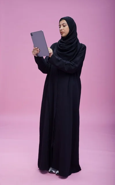 Saudi Woman in Black Abaya Using Tablet in Studio