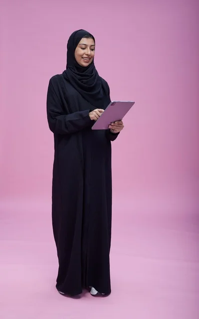 Saudi Woman Using Tablet on Pink Background