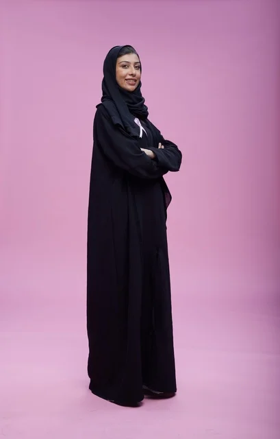 Saudi Woman in Abaya Standing on Pink Background