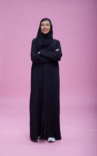Saudi Woman in Black Abaya Standing on Pink Background