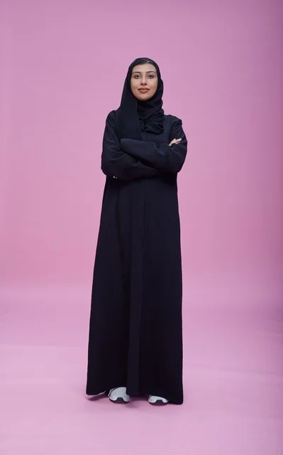 Saudi Woman in Black Abaya on Pink Background