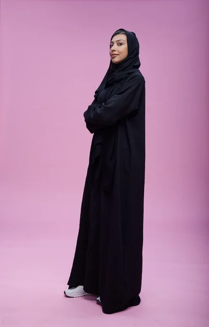 Saudi Woman in Abaya Standing on Pink Background