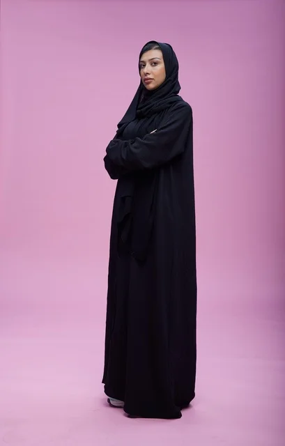 Saudi Woman in Black Abaya on Pink Background