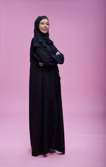 Confident Saudi Woman in Abaya on Pink Background