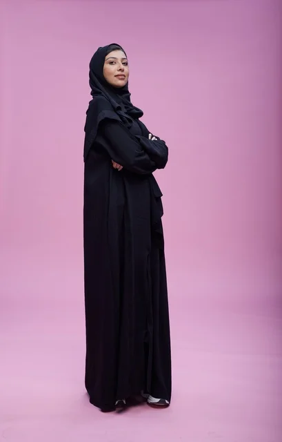 Saudi Woman in Black Abaya on Pink Background