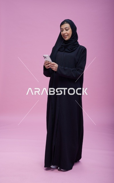 امرأة سعودية تستخدم هاتف ذكي بخلفية وردية