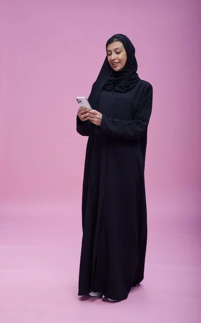 امرأة سعودية تستخدم هاتف ذكي بخلفية وردية