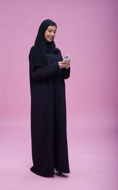 Saudi Woman Using Smartphone in Pink Studio