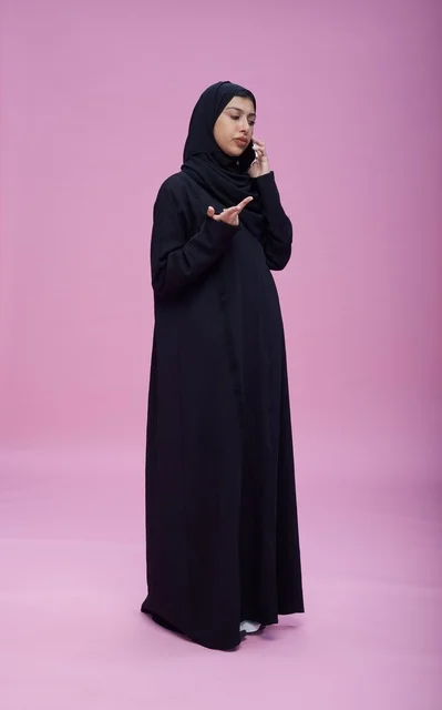 امرأة سعودية تتحدث عبر الهاتف على خلفية أرجوانية