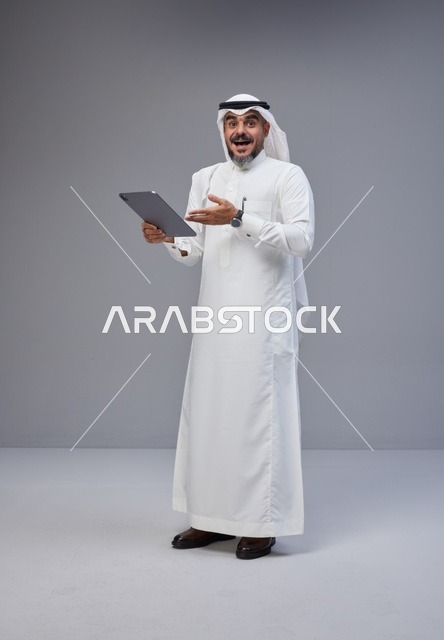 رجل سعودي متفاجئ يستخدم جهاز لوحي في الاستوديو