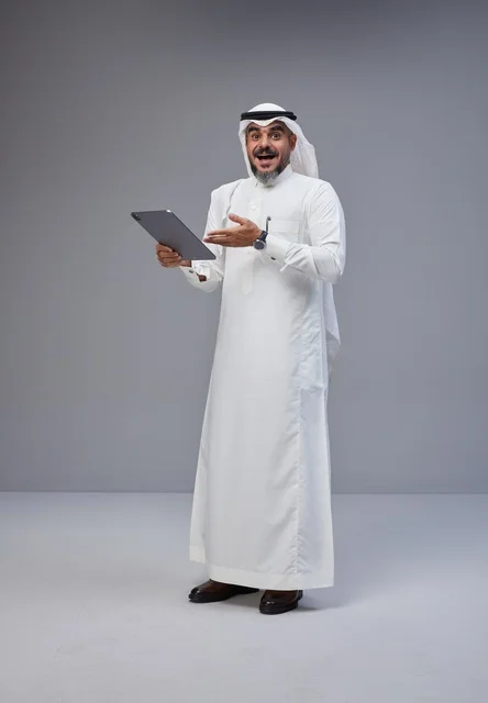 Excited Saudi Man Using Digital Tablet in Studio