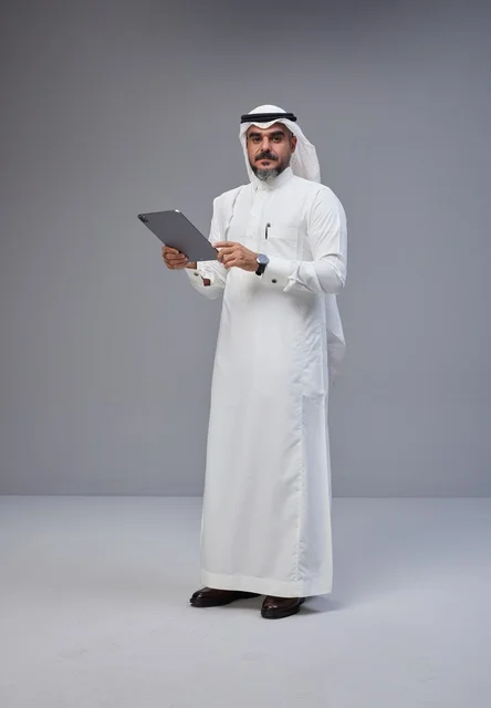 Saudi Man in Traditional Dress Using Tablet in Studio