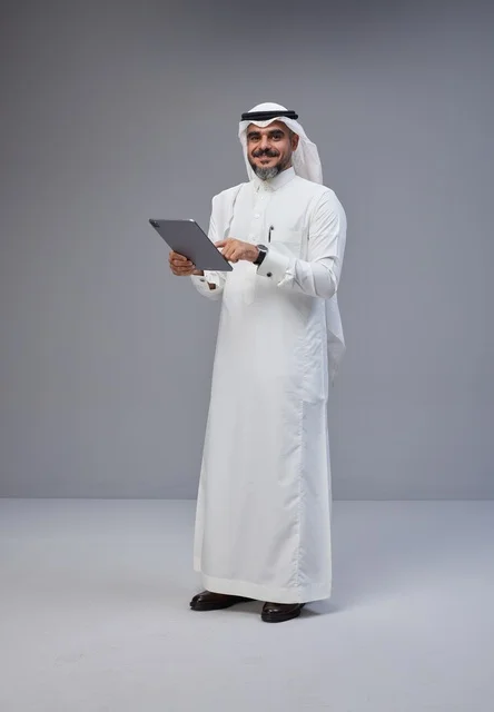 Saudi Man in Traditional Dress Using Tablet in Studio