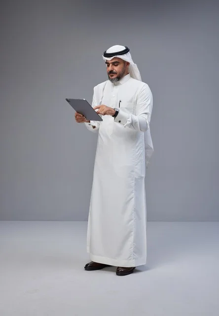 Saudi Man in Traditional Dress Using Tablet in Studio