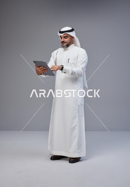 رجل سعودي يستخدم جهازاً لوحياً في استوديو