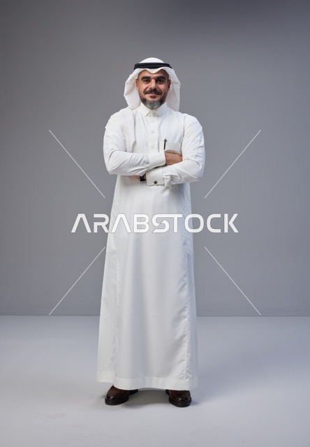 رجل سعودي بالزي التقليدي يقف بثقة في استوديو
