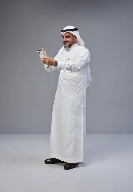 Saudi Man in Traditional Thobe Using Smartphone Studio