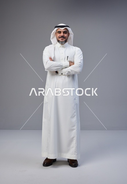 رجل سعودي بالزي التقليدي يقف في استوديو