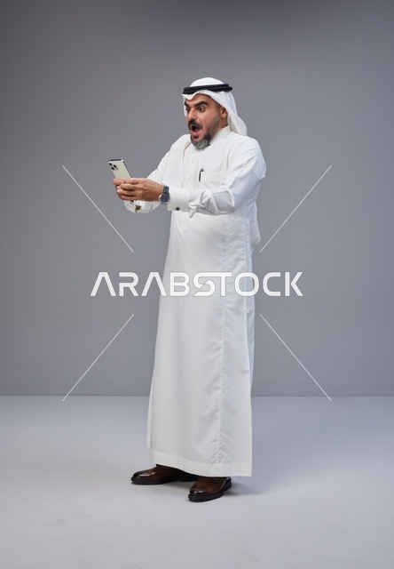 Saudi Man Shocked Looking at Smartphone in Studio