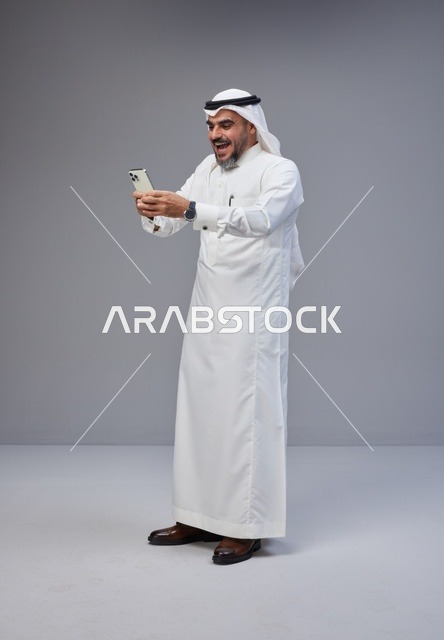 Excited Saudi Man Using Smartphone in Studio
