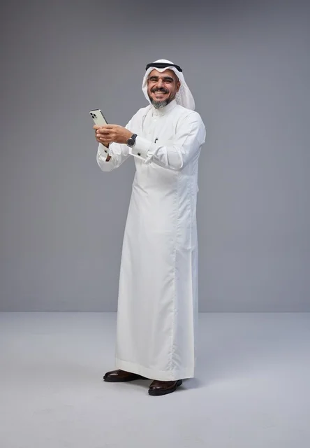Saudi Man in Traditional Thobe Using Smartphone