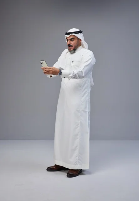 Shocked Saudi Man Using Smartphone in Studio Portrait