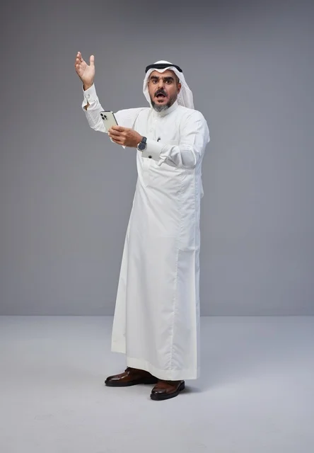 Saudi Man in Traditional Dress Reacting to Smartphone
