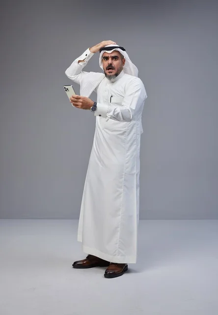 Shocked Saudi Man Looking at Smartphone on Grey Background