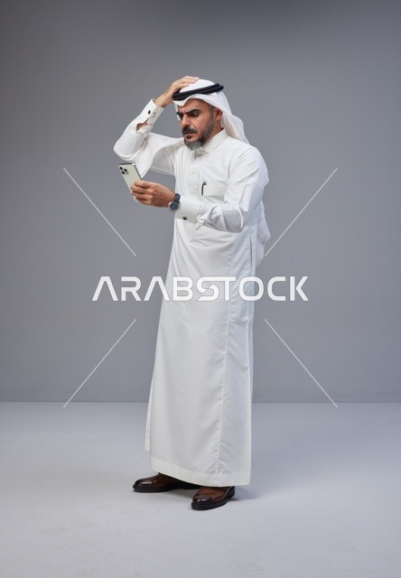 Saudi Man in Traditional Thobe Using Smartphone with Confusion