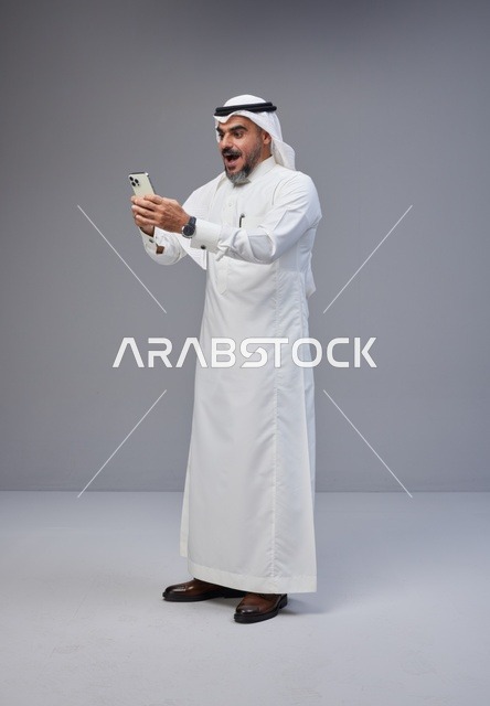 رجل سعودي مندهش يستخدم الهاتف في الاستوديو