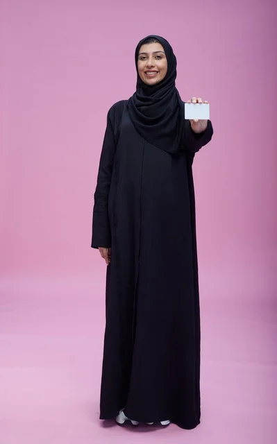 امرأة سعودية تحمل بطاقة بيضاء فارغة خلفية وردية