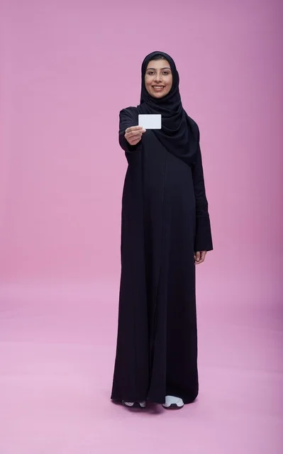 Saudi Woman in Abaya Holding Blank Card on Pink Background