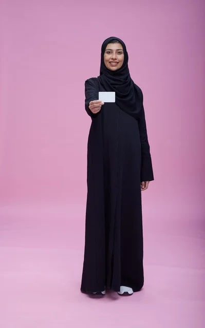 امرأة سعودية بالعباءة تحمل بطاقة فارغة خلفية وردية