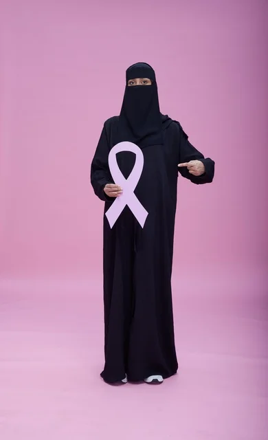 سعودية بالنقاب تحمل شعار التوعية بسرطان الثدي