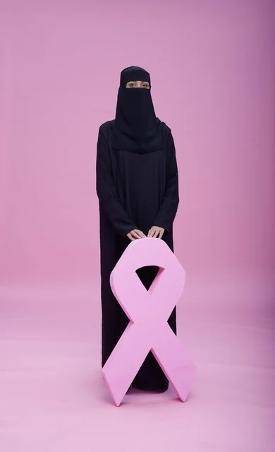 امرأة سعودية بالنقاب وشعار التوعية بسرطان الثدي