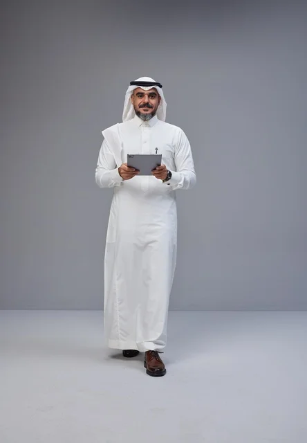 Saudi Man in Traditional Thobe Using Digital Tablet